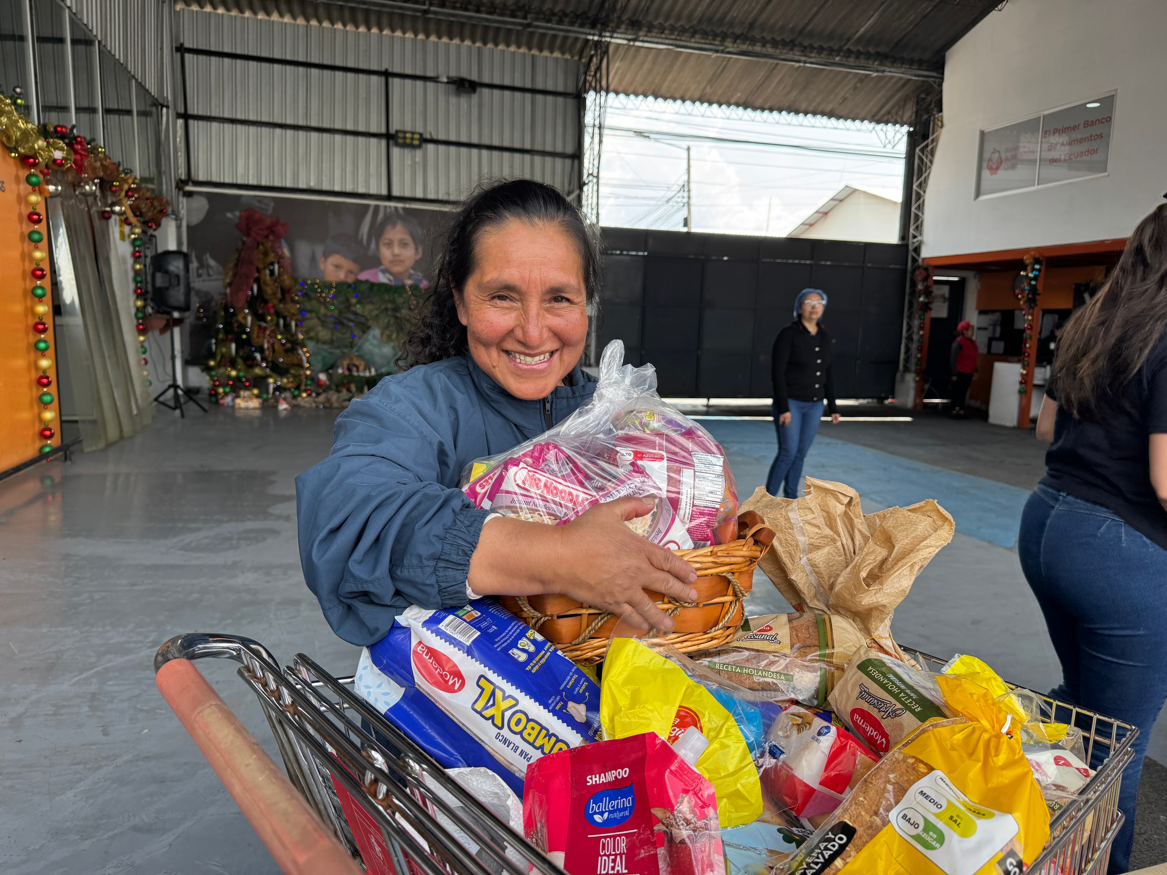 Beneficiaria del Banco de Alimentos de Quito recibiendo productos